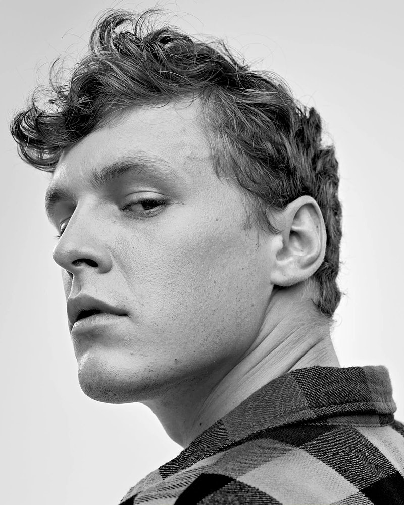 Black and white close-up actor headshot of a young man with a focused expression.