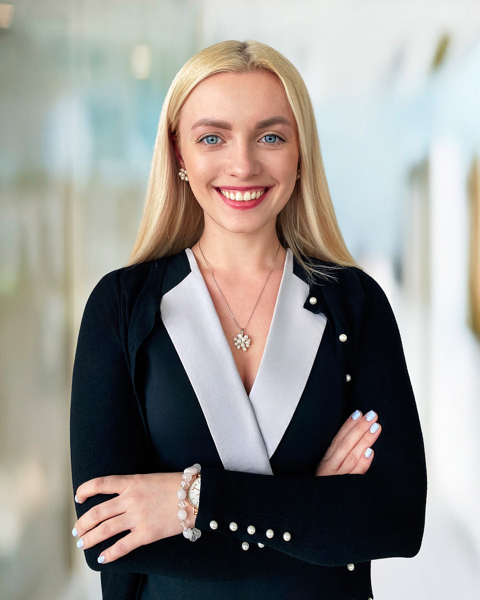 Modern studio headshot of a woman with a natural expression on a gray background.